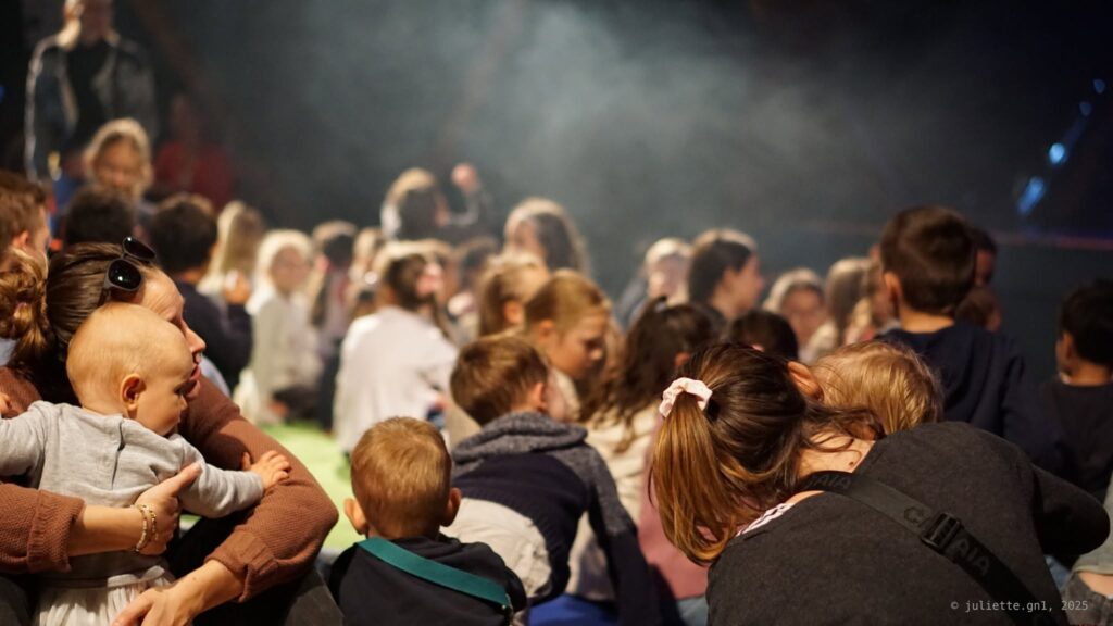 Des enfants de dos assistant à un spectacle